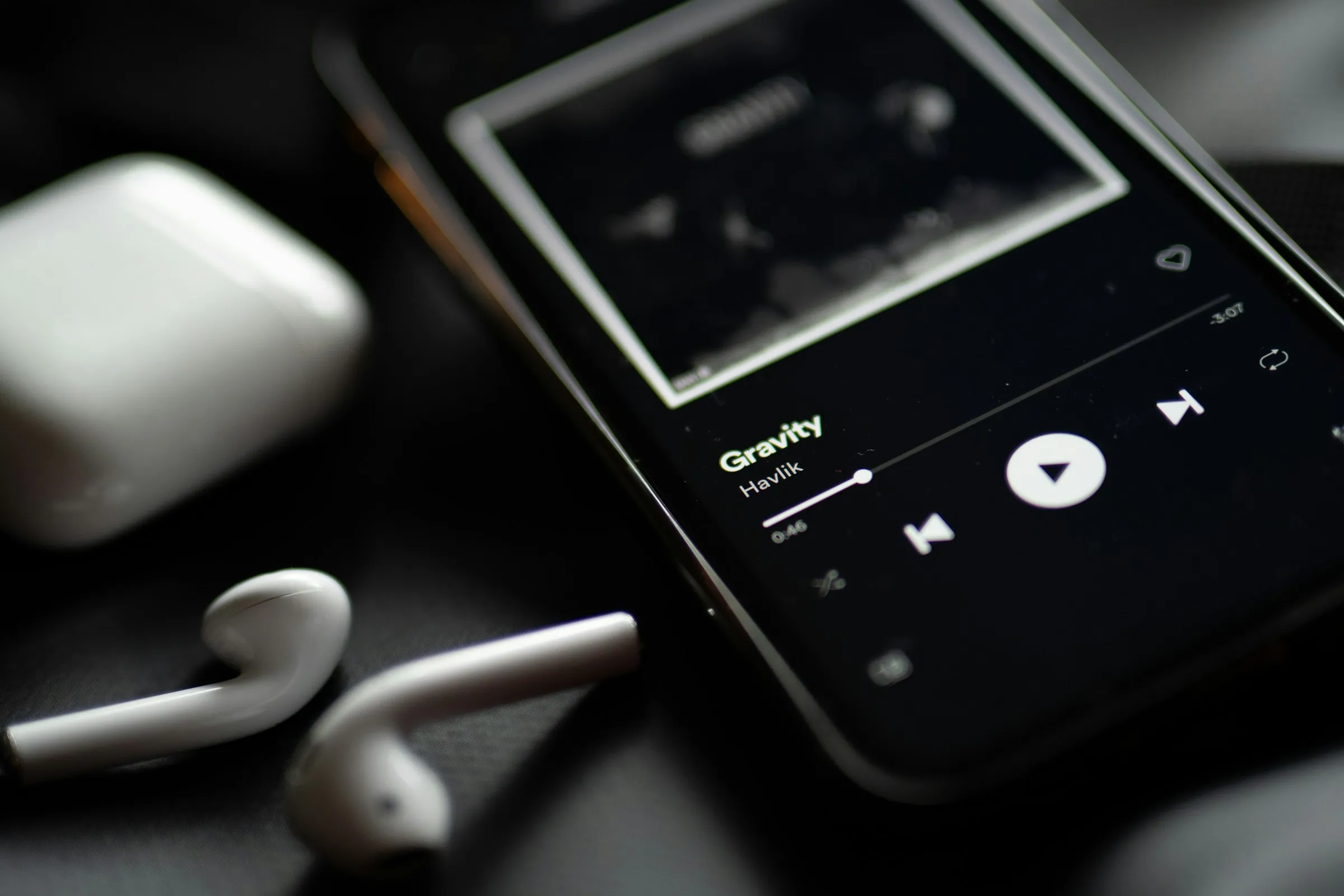 Streaming platform displayed on a phone with headphones beside it, illustrating music access options.