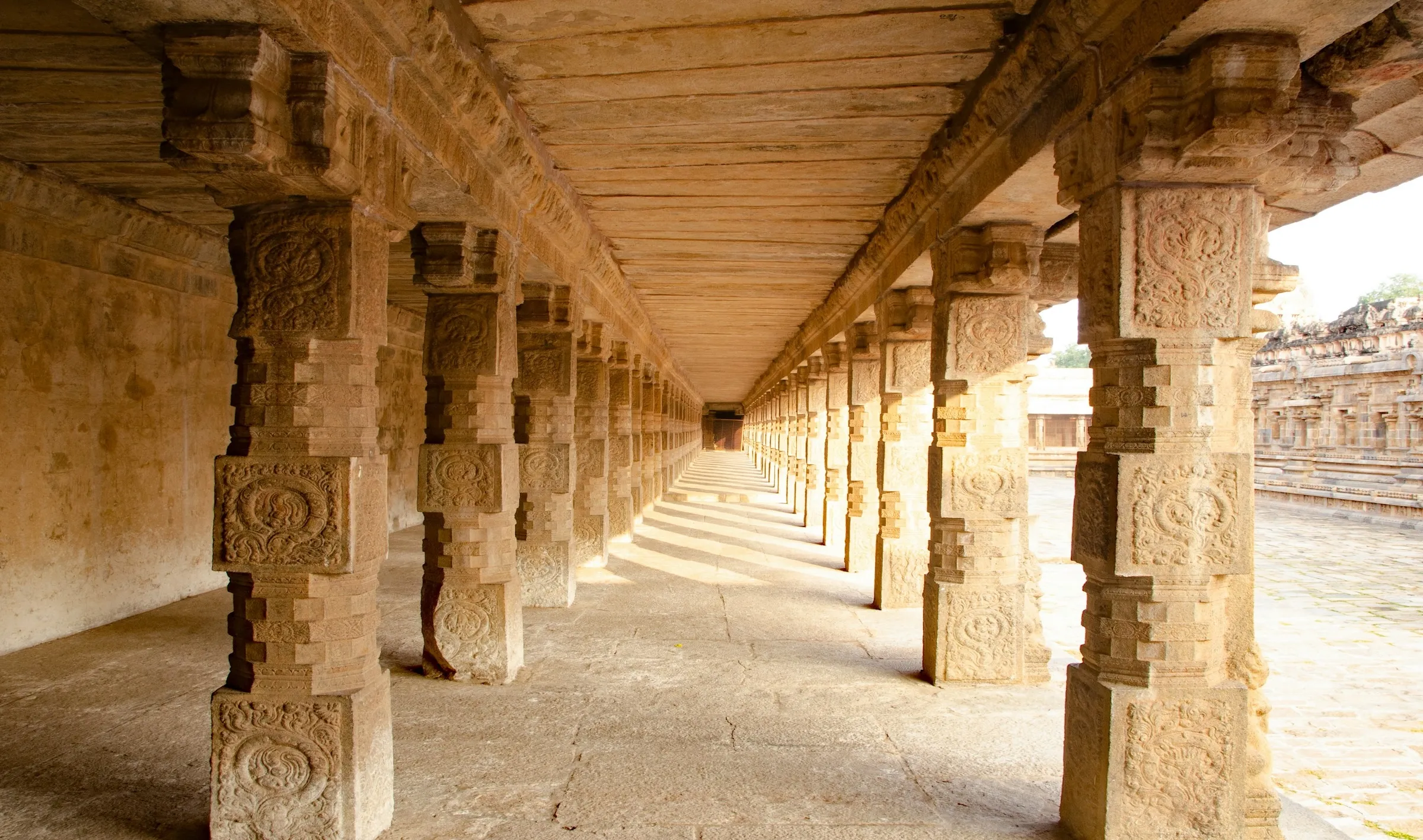 Majestic pillars stand in the courtyard of an ancient temple, showcasing intricate carvings and historical significance.