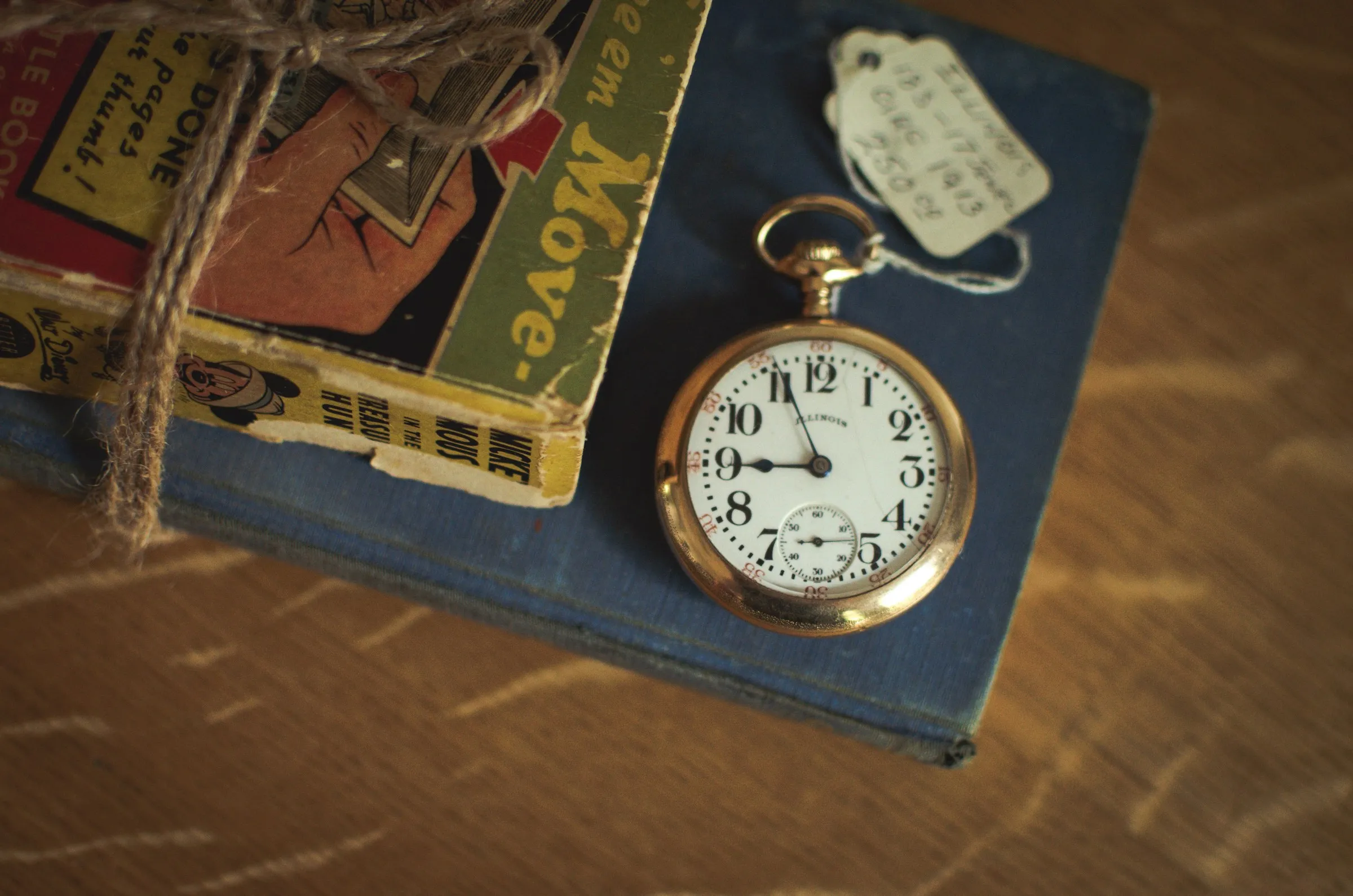 An elegant pocket watch placed on a book, highlighting the contrast between the timepiece and the textured pages.